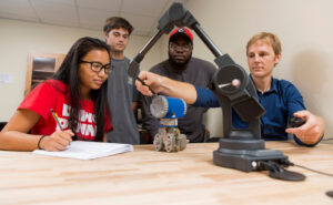 Students and faculty work with robotic device