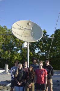 Katie and a group of students in front of satellite dish