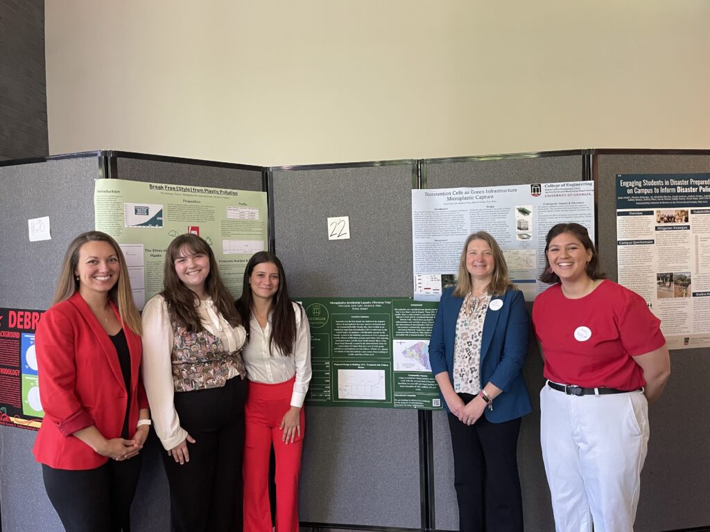 Group of women stands in front of research posters