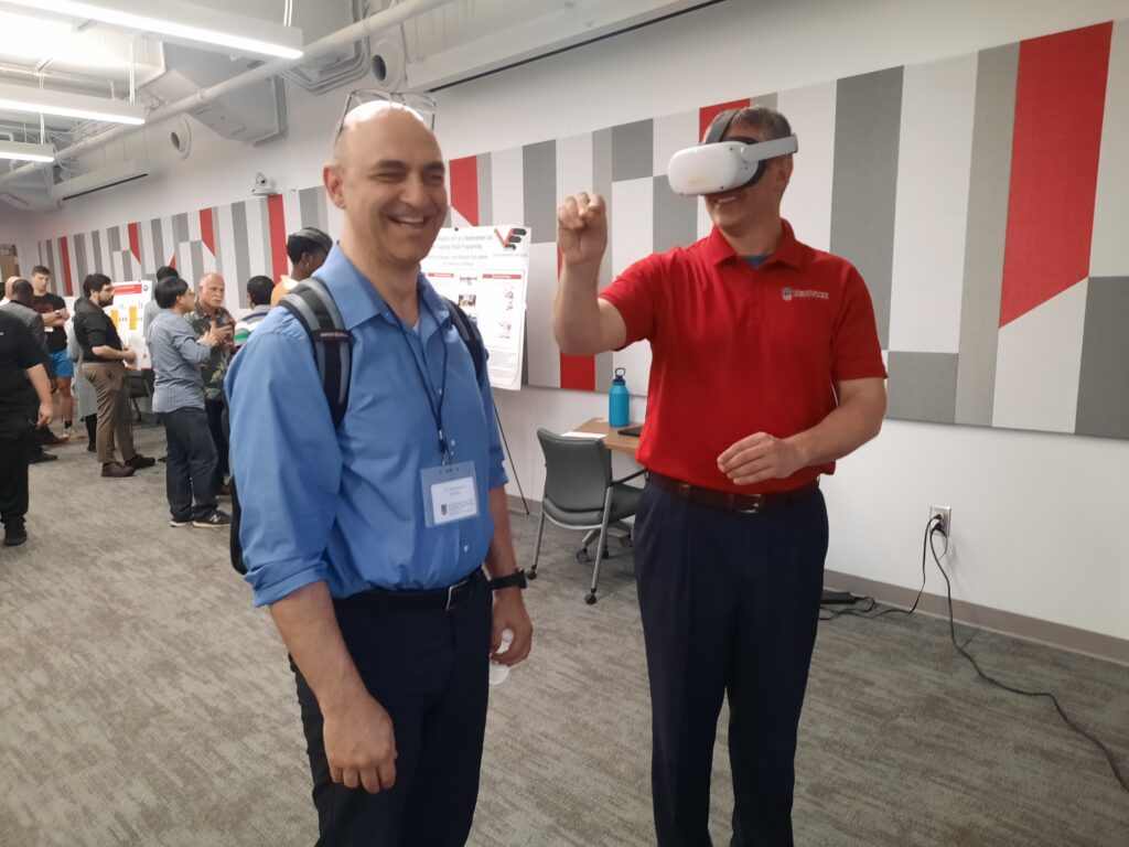 A pair of faculty, one wearing VR goggles