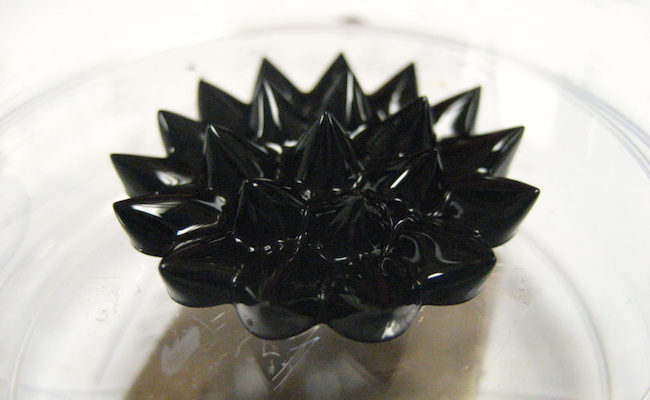Ferrofluids form a spiking pattern on top of a rectangular permanent magnet.