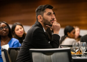 Abolfazl Najar with a hand to his chin, sitting at a conference table looking off-camera