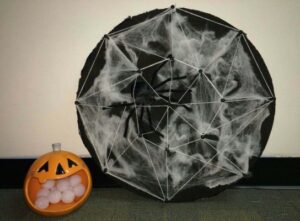 Disk with spiderweb next to ceramic pumpkin