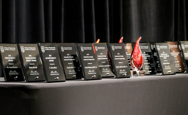 a large array of black plaques and red blown glass awards sitting on a black table