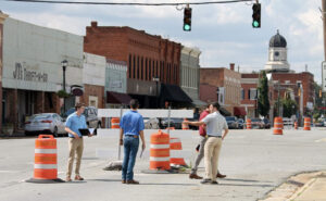 Students survey roadway in a downtown area