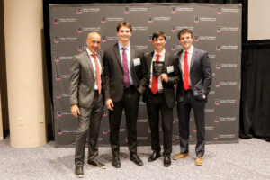 group of capstone students posing with dean and faculty