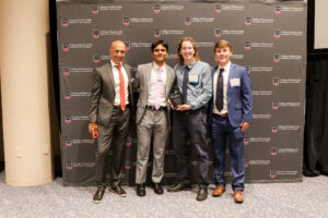 group of capstone students posing with dean and faculty