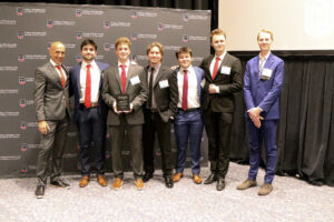 group of capstone students posing with dean and faculty