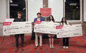 students pose with giant checks