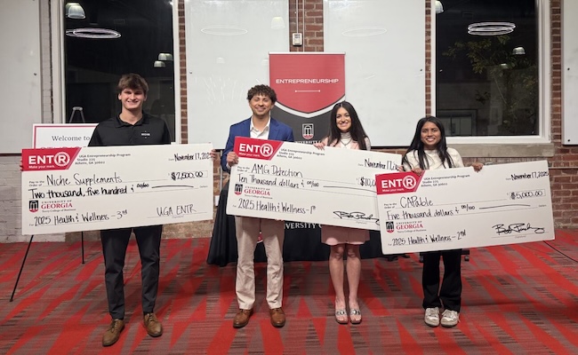 students pose with giant checks