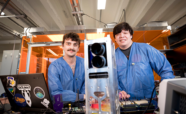 Caleb Adams, left, and Graham Grable work on a satellite project in the Small Satellite Lab.