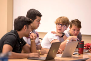 Students in Benjamin Manning's informatics class collaborate on a group project.