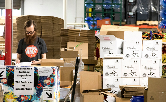 Kindercore employee with cardboard boxes of supplies