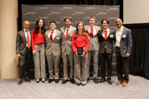 group of capstone students posing with dean and faculty