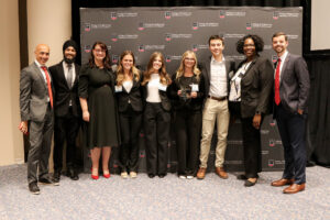 group of capstone students posing with dean and faculty