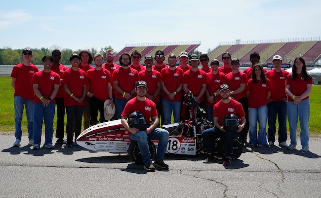 UGA Motorsports team poses with vehicle on the racetrack.