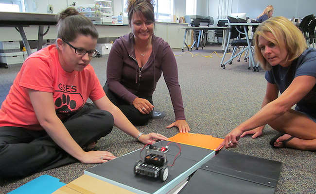 Student and teachers work with robot