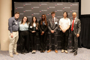 group of capstone students posing with dean and faculty
