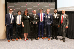 group of capstone students posing with dean and faculty